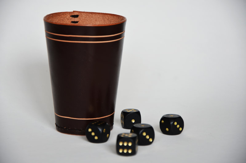 Würfelbecher aus Leder mit drei Linien ringsherum.