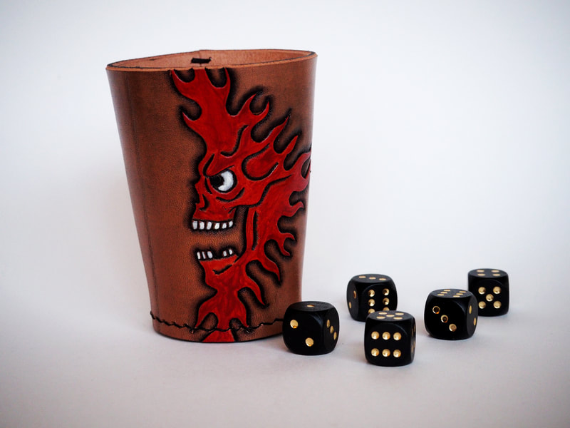 Würfelbecher aus Leder mit punziertem Feuermonster.