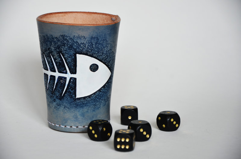 Würfelbecher aus Leder mit punziertem Fischskelett.