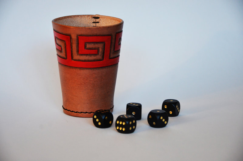 Würfelbecher aus Leder mit punziertem grieschischem Ornament.