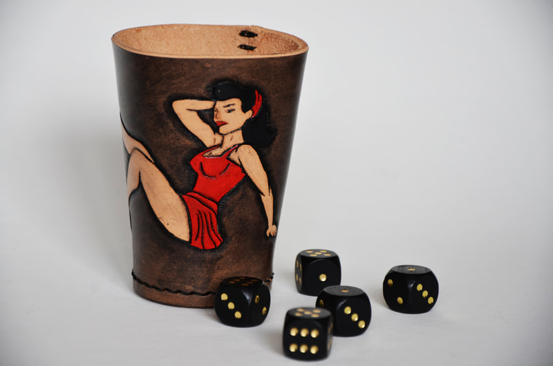 Würfelbecher aus Leder mit Pinup-Girl in rotem Keid.