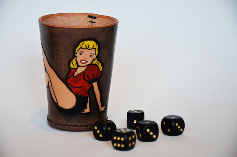 Würfelbecher aus Leder mit Pinup-Girl sitzend.