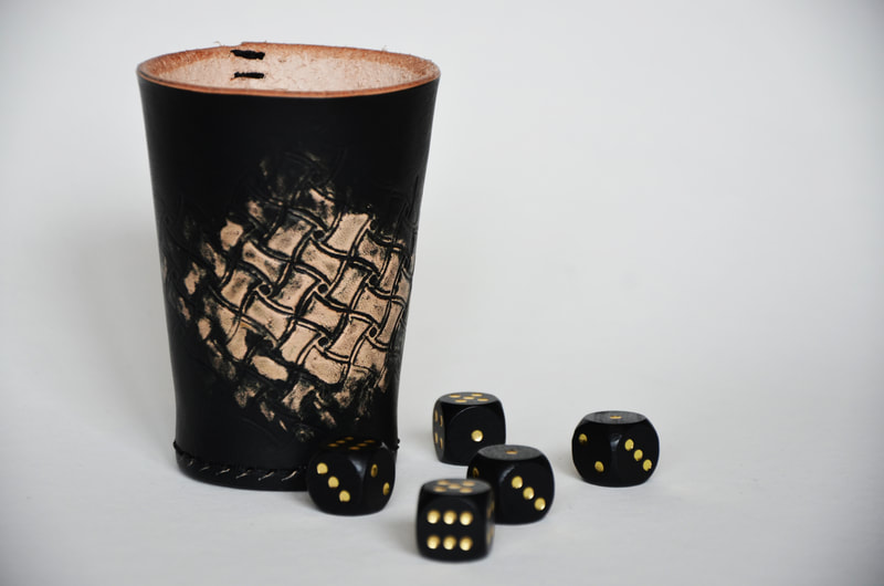 Würfelbecher aus Leder mit teilweise Rauten Motiv.