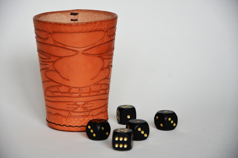Würfelbecher aus Leder mit Tiki Kopf Motiv.