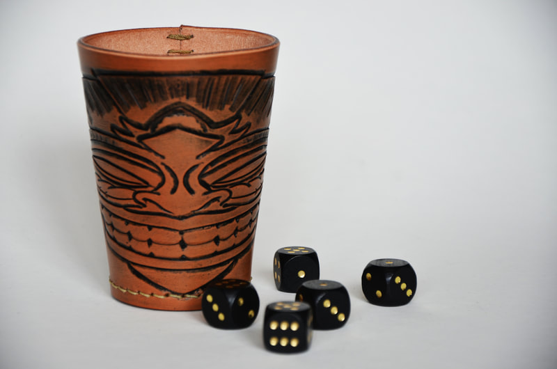Würfelbecher aus Leder mit Tiki Kopf Motiv.