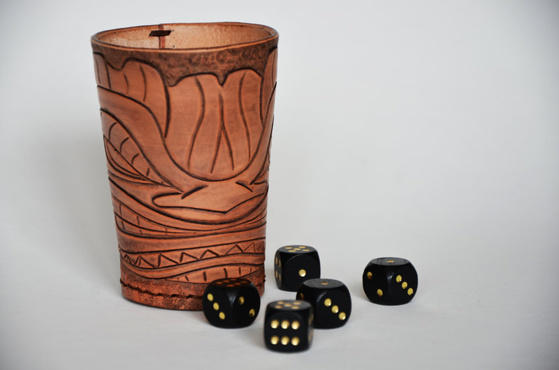 Würfelbecher aus Leder mit Tiki Kopf Motiv.