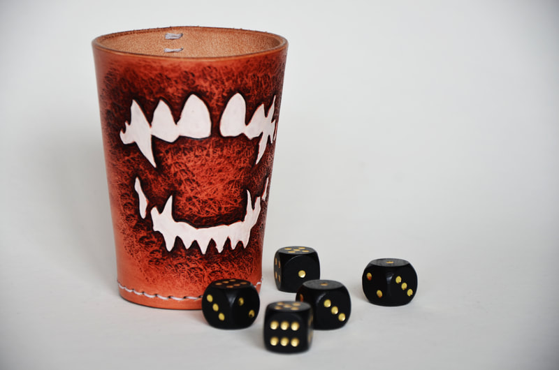 Würfelbecher aus Leder mit Vampirgebiss Motiv.